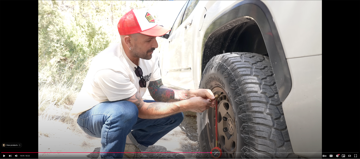 Vin_tra kneeling down to a fifteen52 Turbomac HD wheel mounted to a Yokohama Geolander tire so he can air it down to 20psi for improved off road driving performance