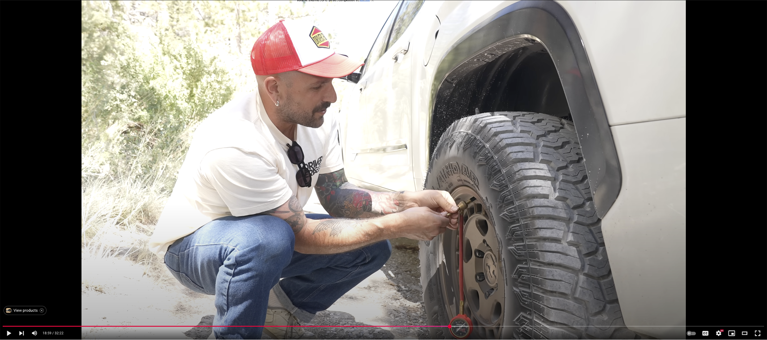 Vin_tra kneeling down to a fifteen52 Turbomac HD wheel mounted to a Yokohama Geolander tire so he can air it down to 20psi for improved off road driving performance
